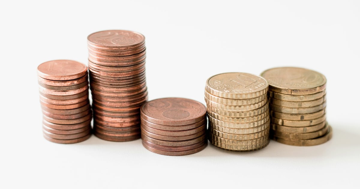 Stacks of copper and gold-colored coins of different heights on a white background